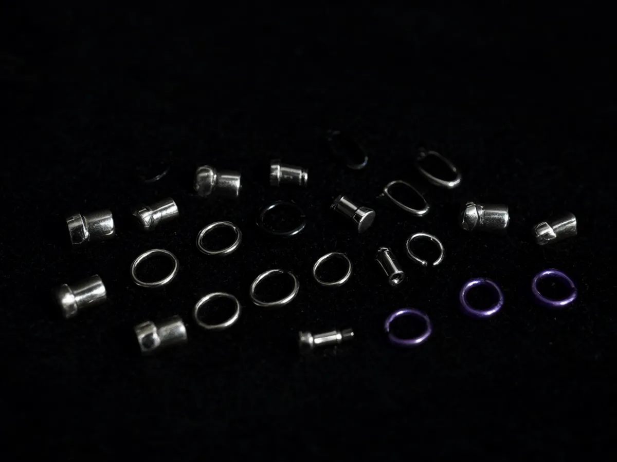 Titanium studs, hoops and curved barbells laid out on black velvet